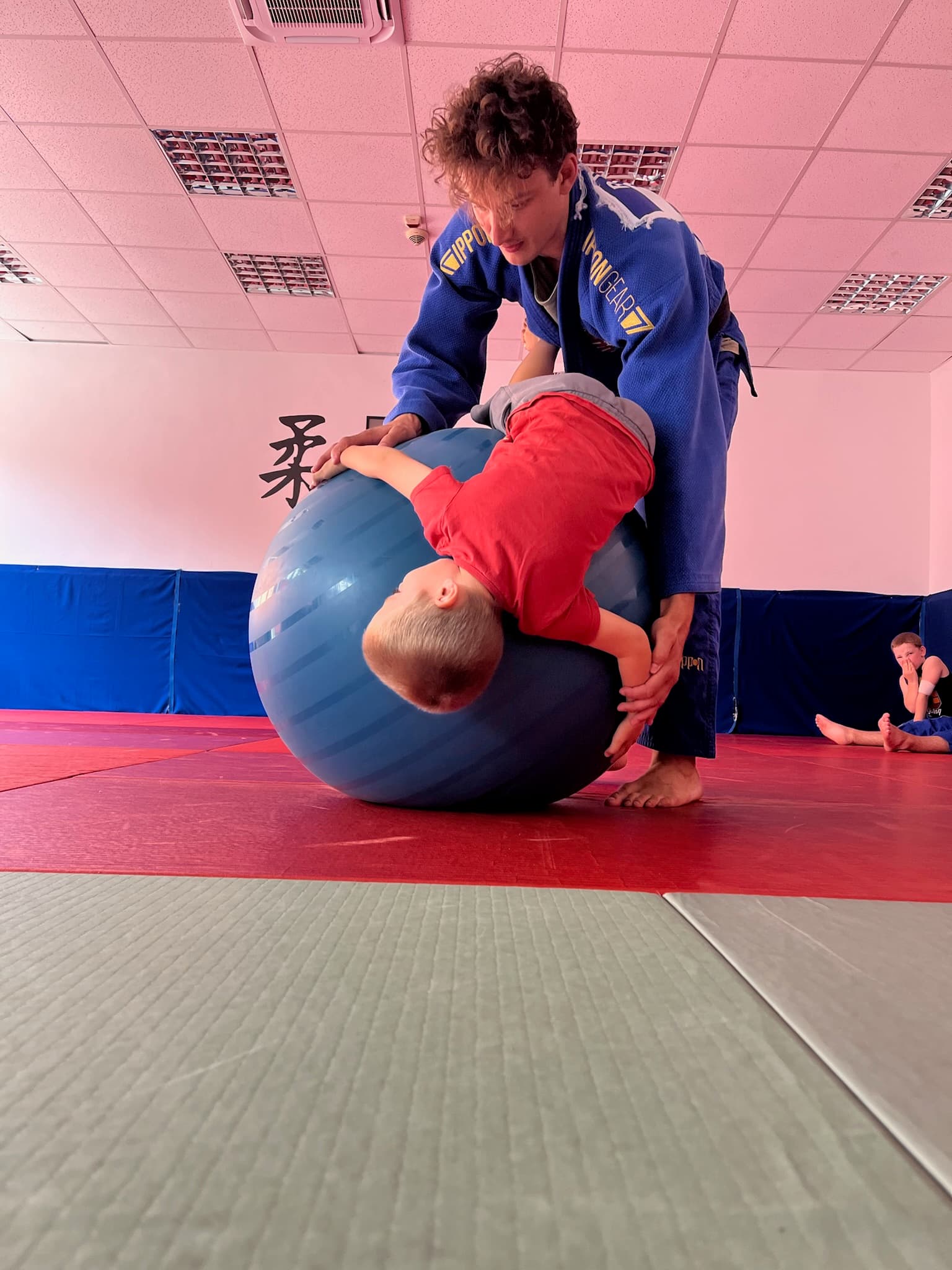 Edző és kisgyermek judo alapmozgás gyakorlása tatamin